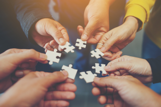 people holding puzzle pieces