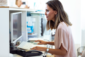 Medical staff typing at a computer in a clinic.