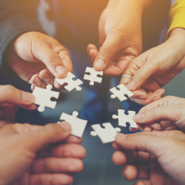 people holding puzzle pieces